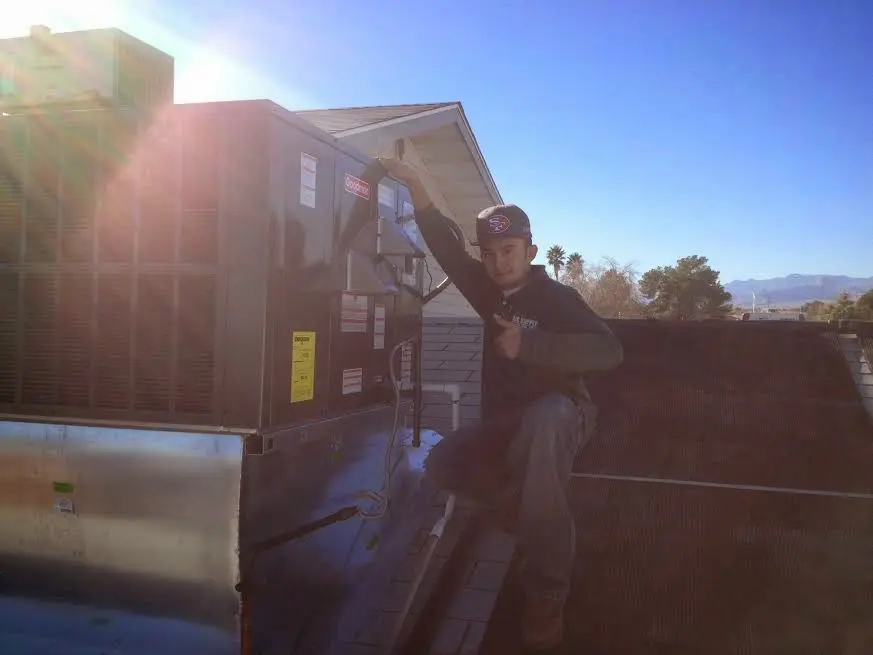 HVAC technician performing Air Duct Cleaning on a rooftop unit in Soquel